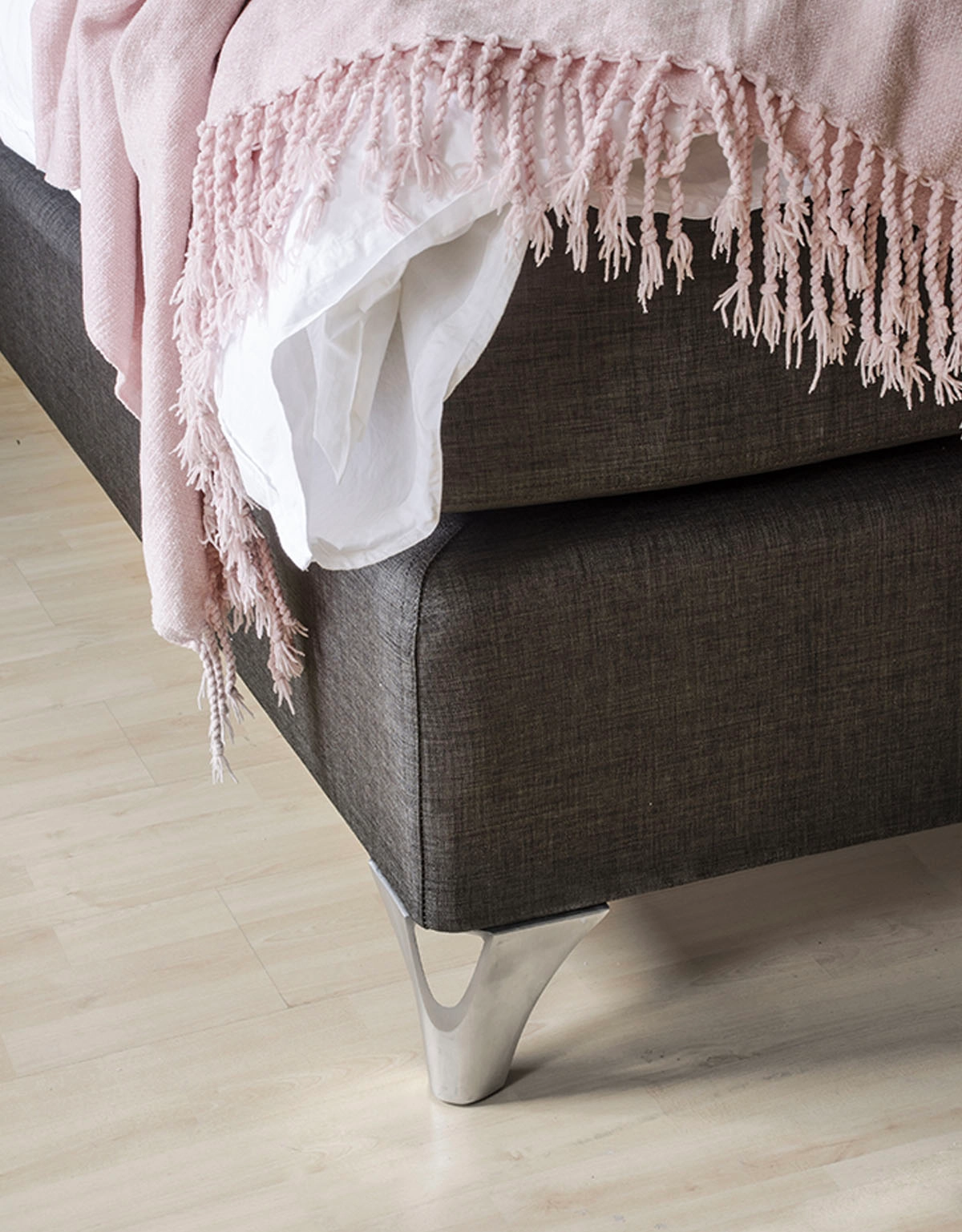 Sängben i borstat stål på en mörkgrå kontinentalsäng