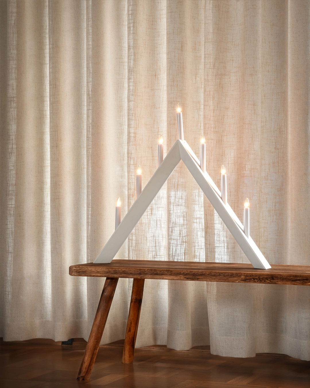 Beige gardin bakom ljusstake.