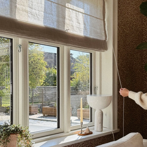 Beige hissgardin i lantligt fönster