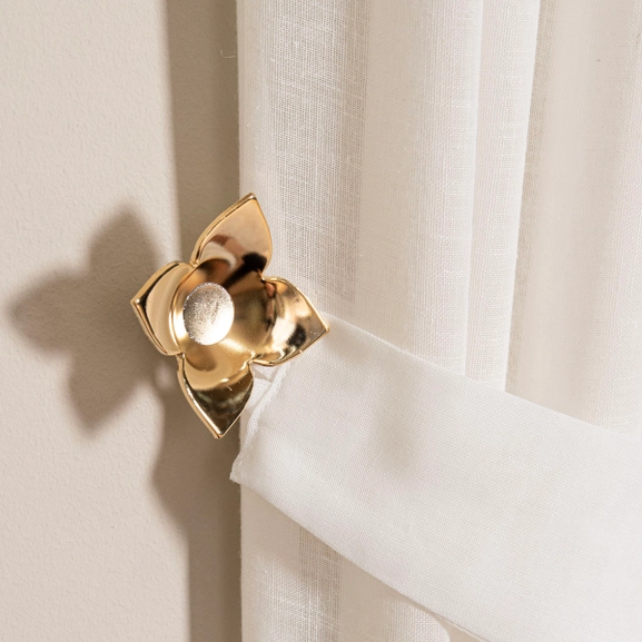 Fäste till gardinomtag i form av en guldig ros