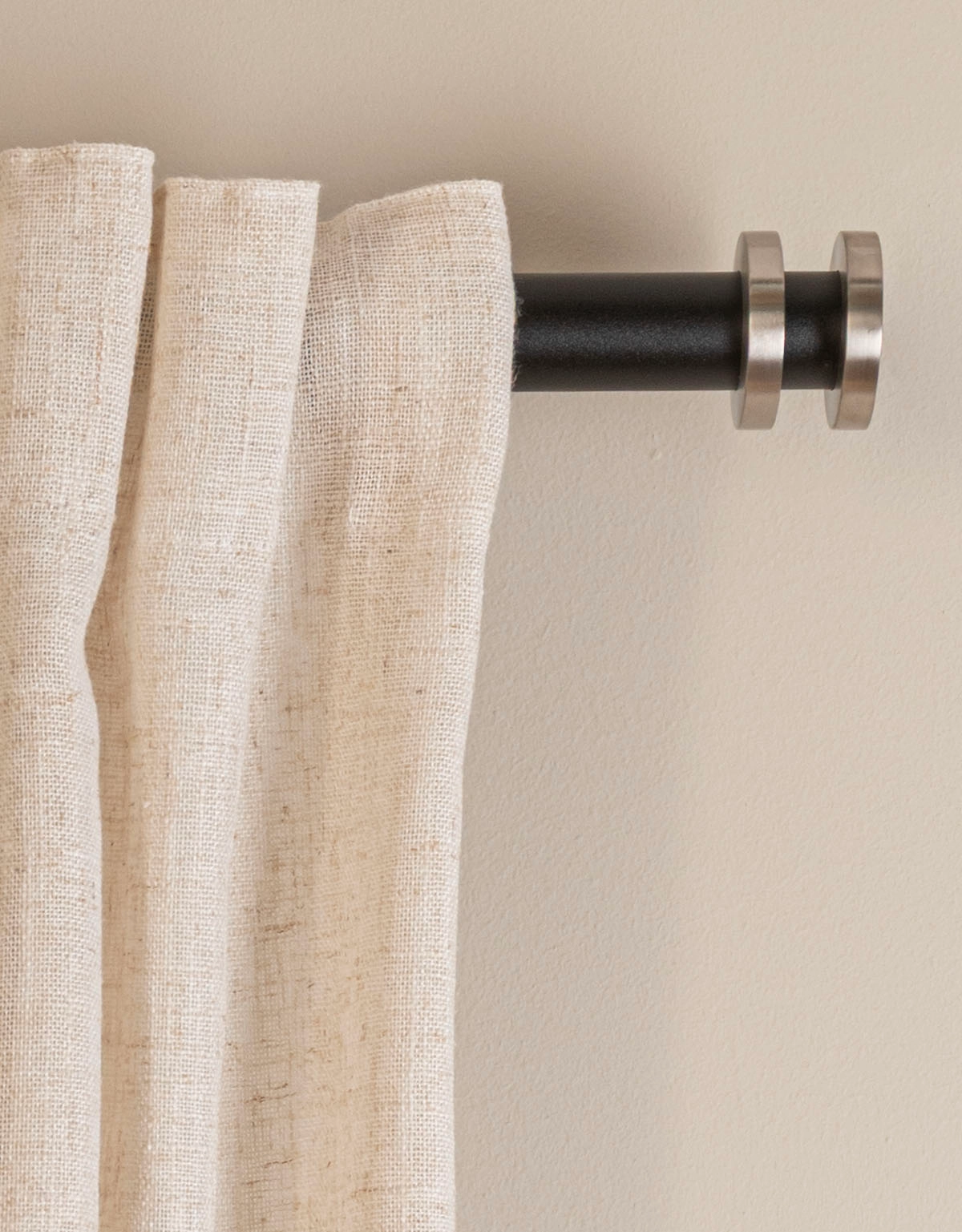 Svart gardinstång med stångdekor och ändknopp i rostfritt stål