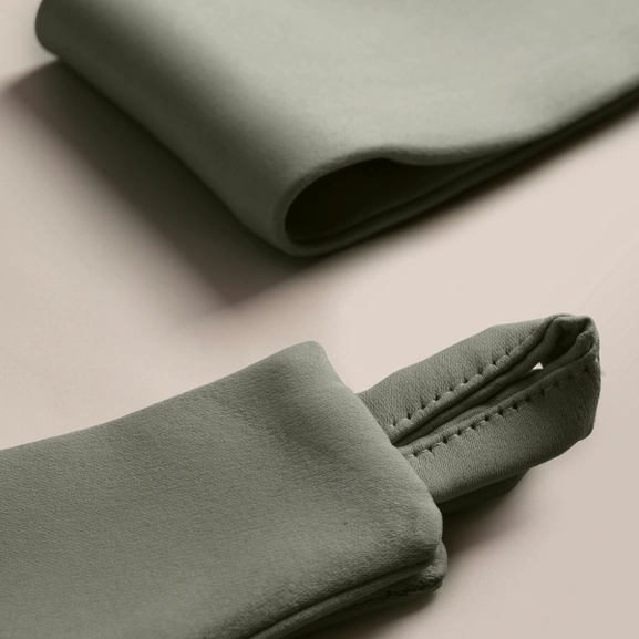 Närbild på mörkgrönt gardinomtag i tyg