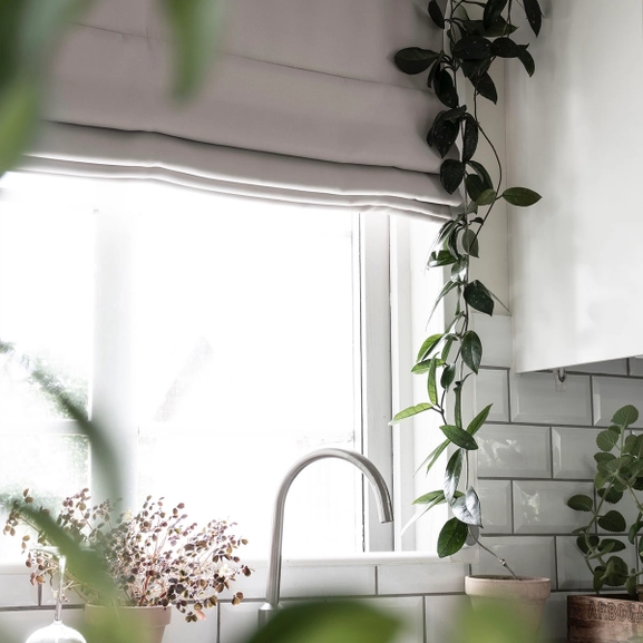 Mörkläggande ljusgrå hissgardin i kök