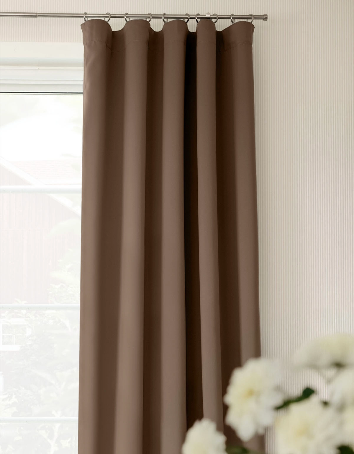 Brun mörkläggningsgardin på gardinstång