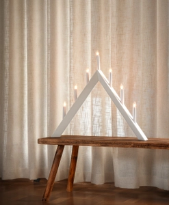 Beige gardin bakom ljusstake.
