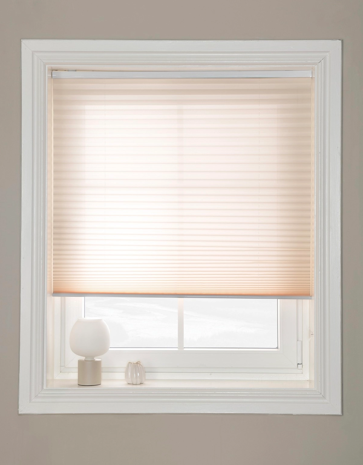 Beige plisségardin i fönster