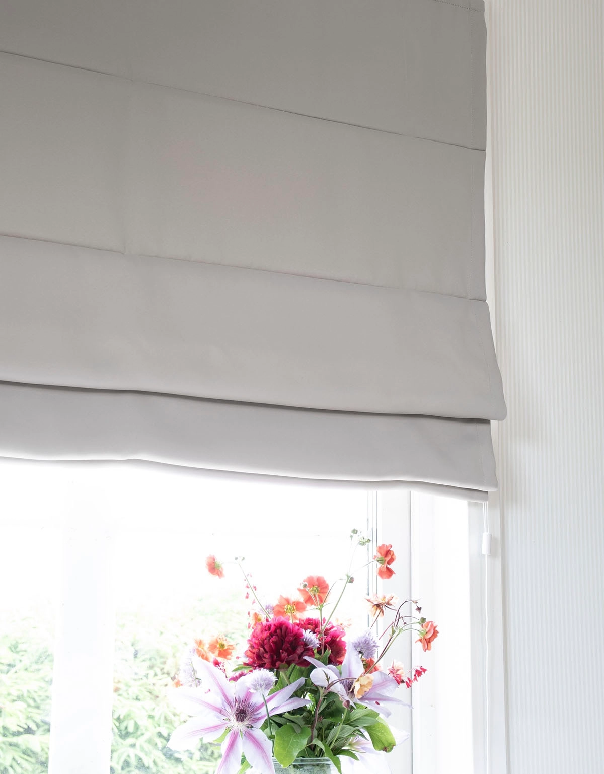 Mörkläggande ljusgrå hissgardin i fönster