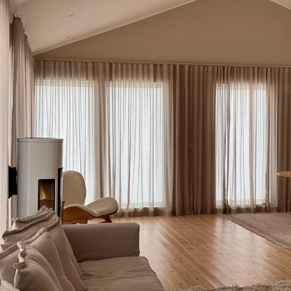 Beige gardin över stort fönsterpari
