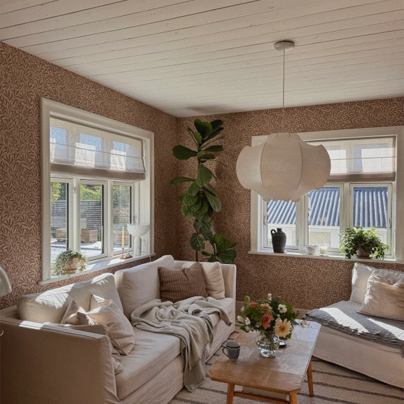 Beige hissgardin i vardagsrum med mönstrade tapeter