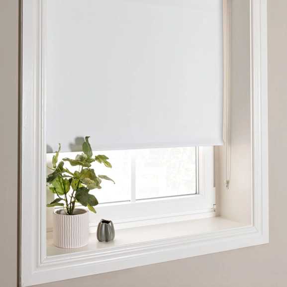 Vit mörkläggande rullgardin monterad i nisch