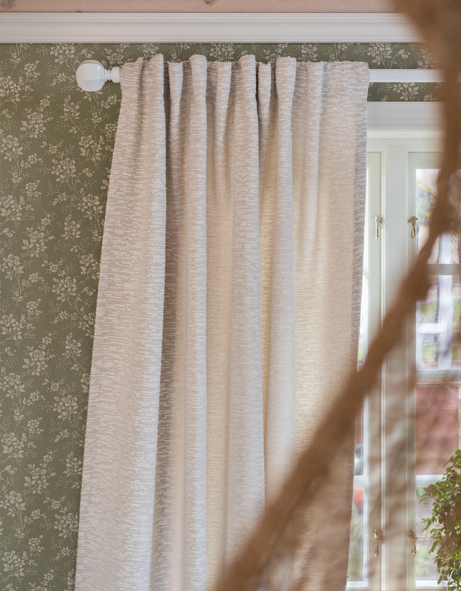 Ljusgrå bouclégardin på vit gardinstång