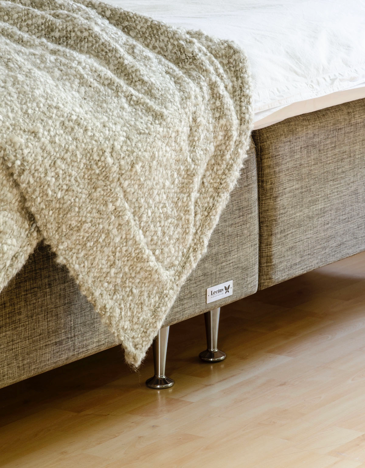 Sängben i aluminium på en brun säng