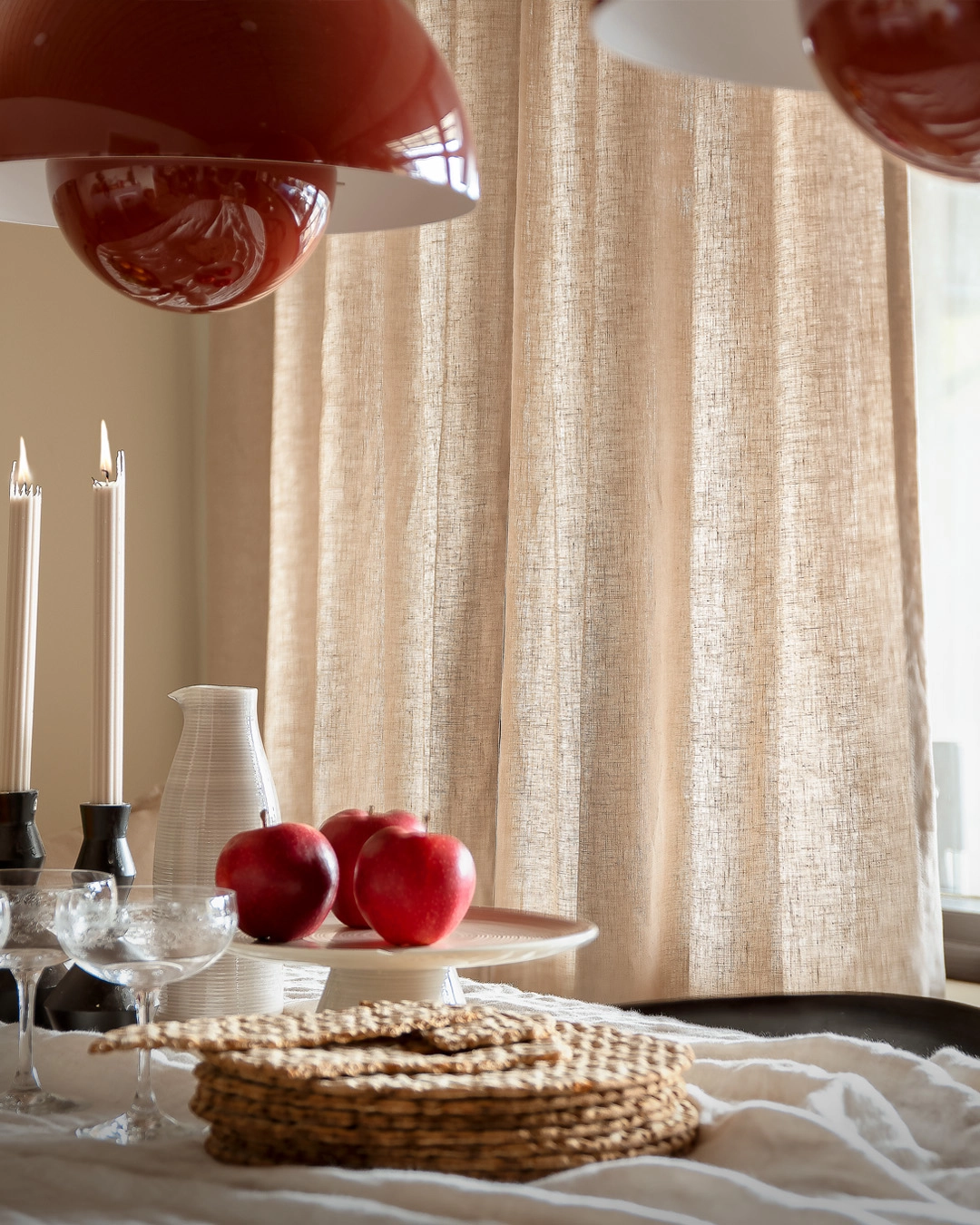 Beige gardin i bakgrunden av ett dukat julbord.