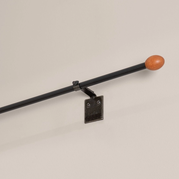 Svart gardinstång med oval knopp i trä