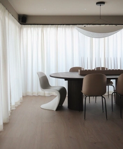 Vit gardin på svart gardinskena monterad på vägg