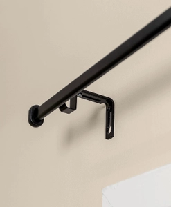 Svart gardinstång med väggfäste
