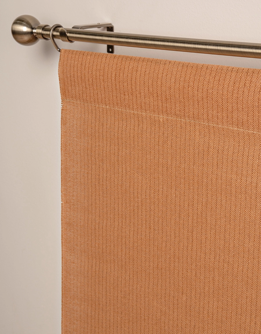 Närbild på orange panelgardin med struktur