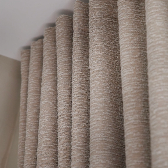 Närbild på vågorna på en bouclégardin i beige nyans