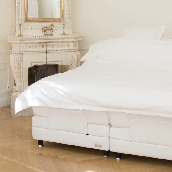 Vit säng i klassisk miljö med svarta sängben