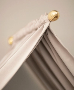 Sänghimmel i mässing, med mörkläggande tyg i beiget