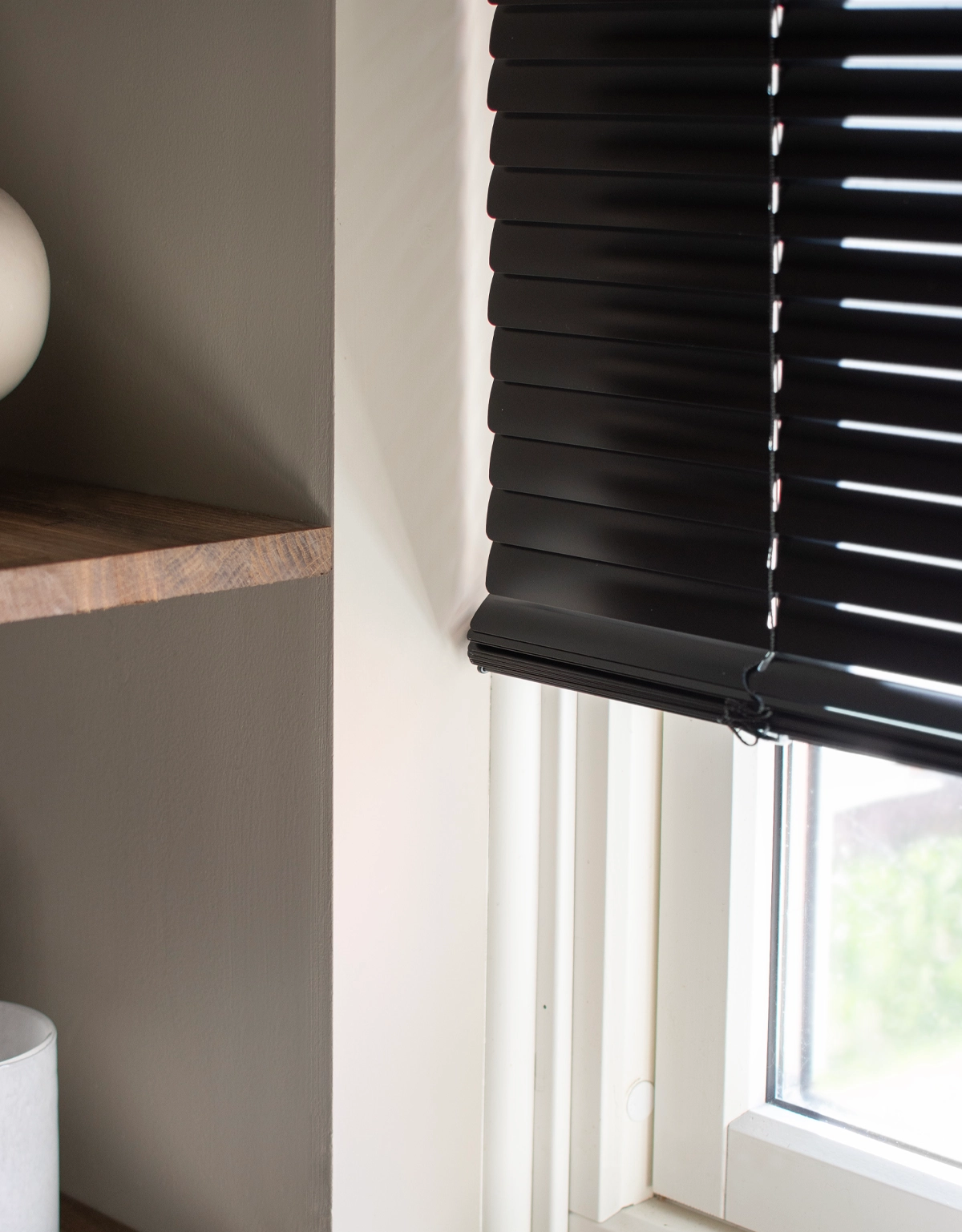 Närbild på lamellerna på en svart persienn