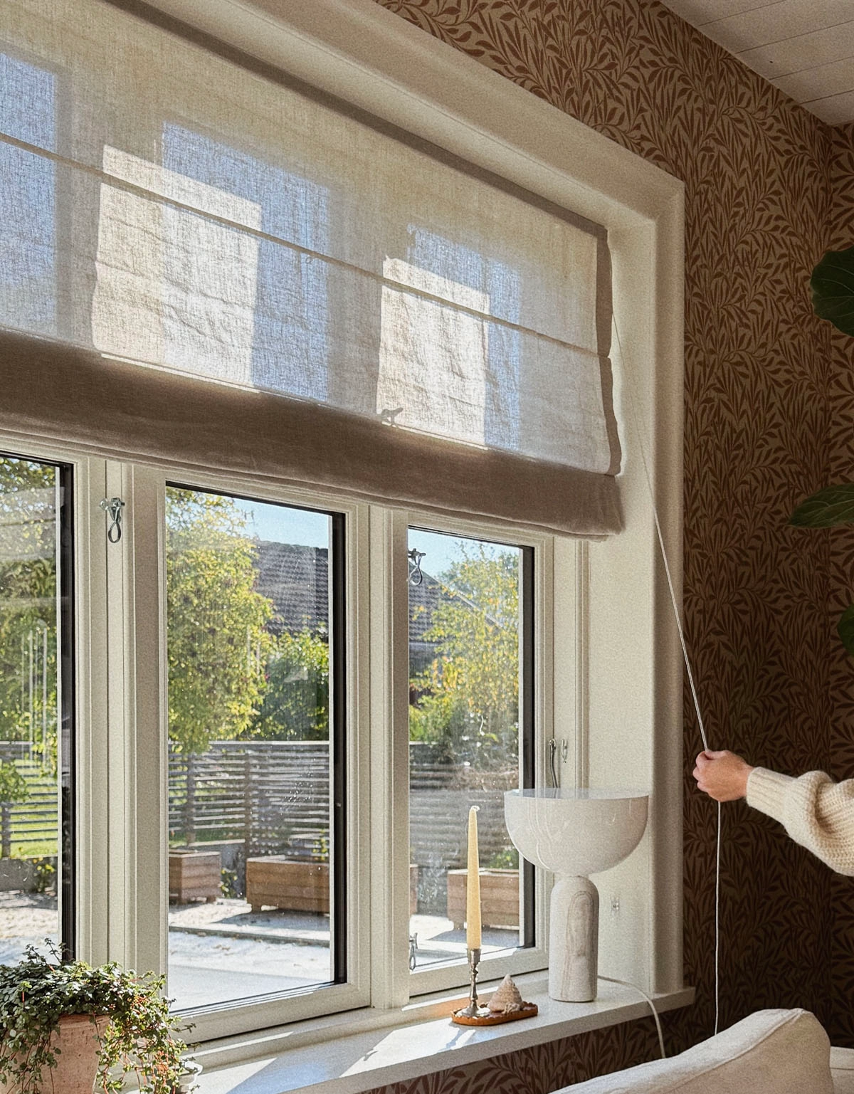 Beige hissgardin i lantligt fönster