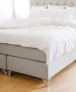 Sängben i stål på ljusgrå säng