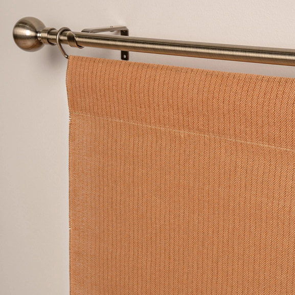 Närbild på orange panelgardin med struktur