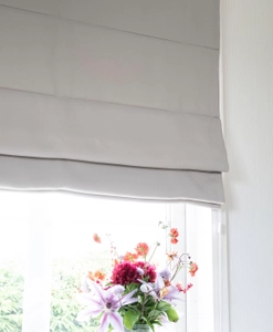 Mörkläggande ljusgrå hissgardin i fönster