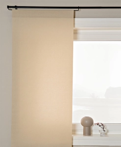 Beige panelgardin på gardinstång med panelhängare