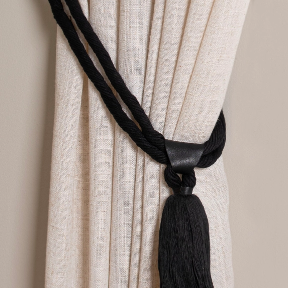 Svart gardinomtag med tofs och detalj i läder