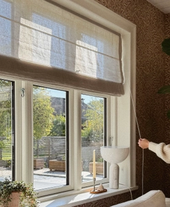 Beige hissgardin i lantligt fönster