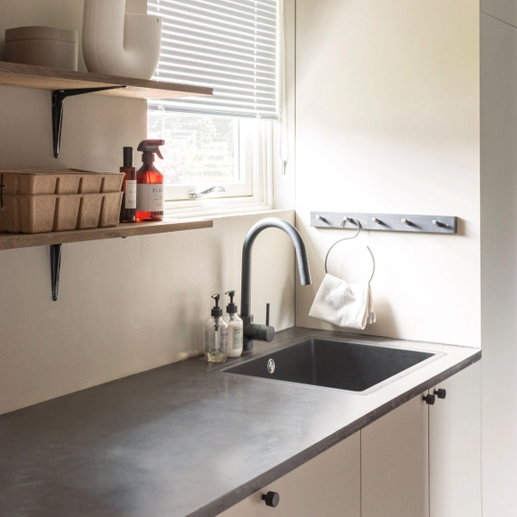 Vit persienn med skruvfri montering i tvättstuga