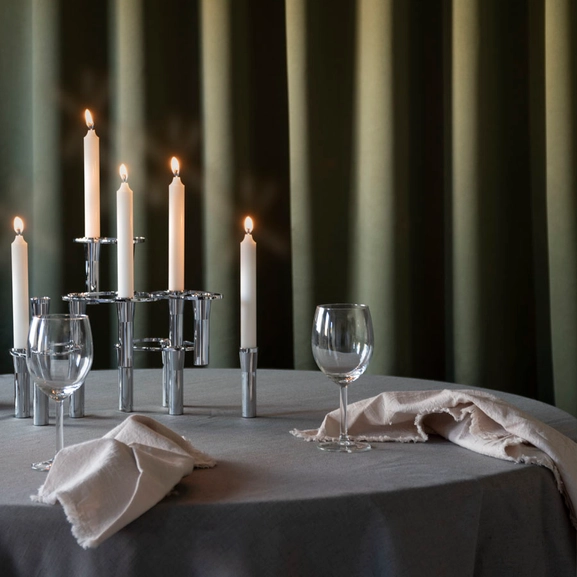 Grön gardin bakom ett bord med tända ljus