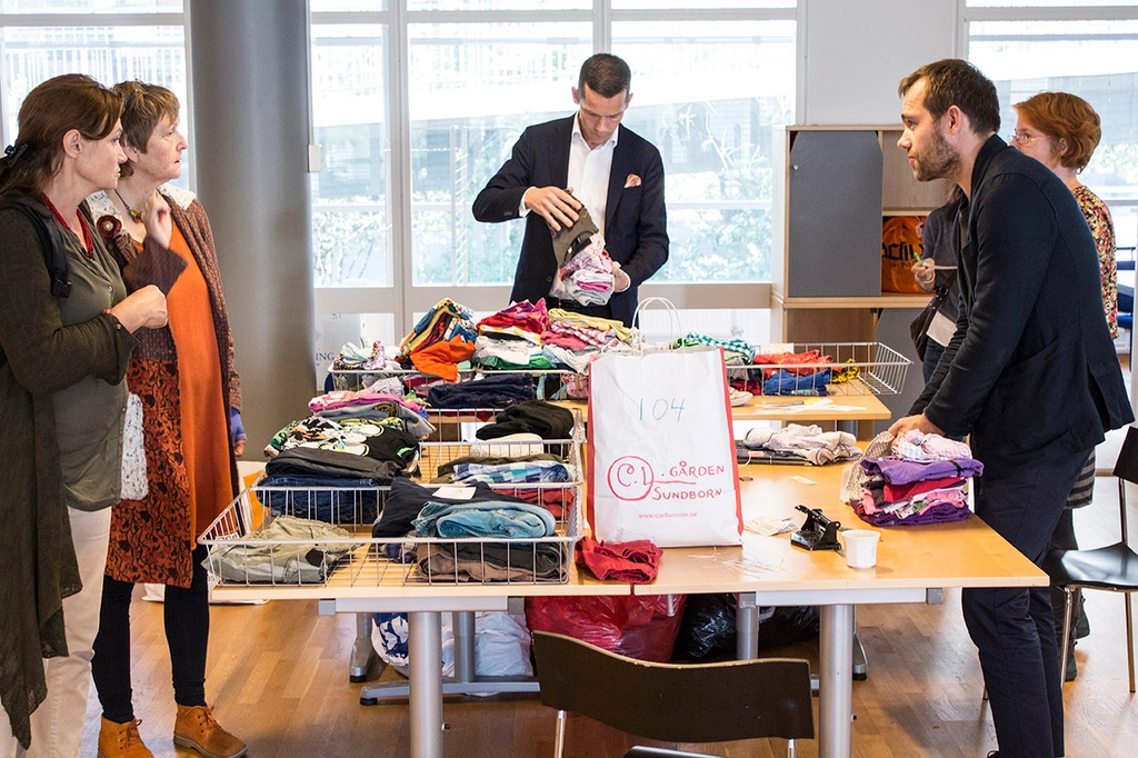 Människor som handlar kläder på loppis