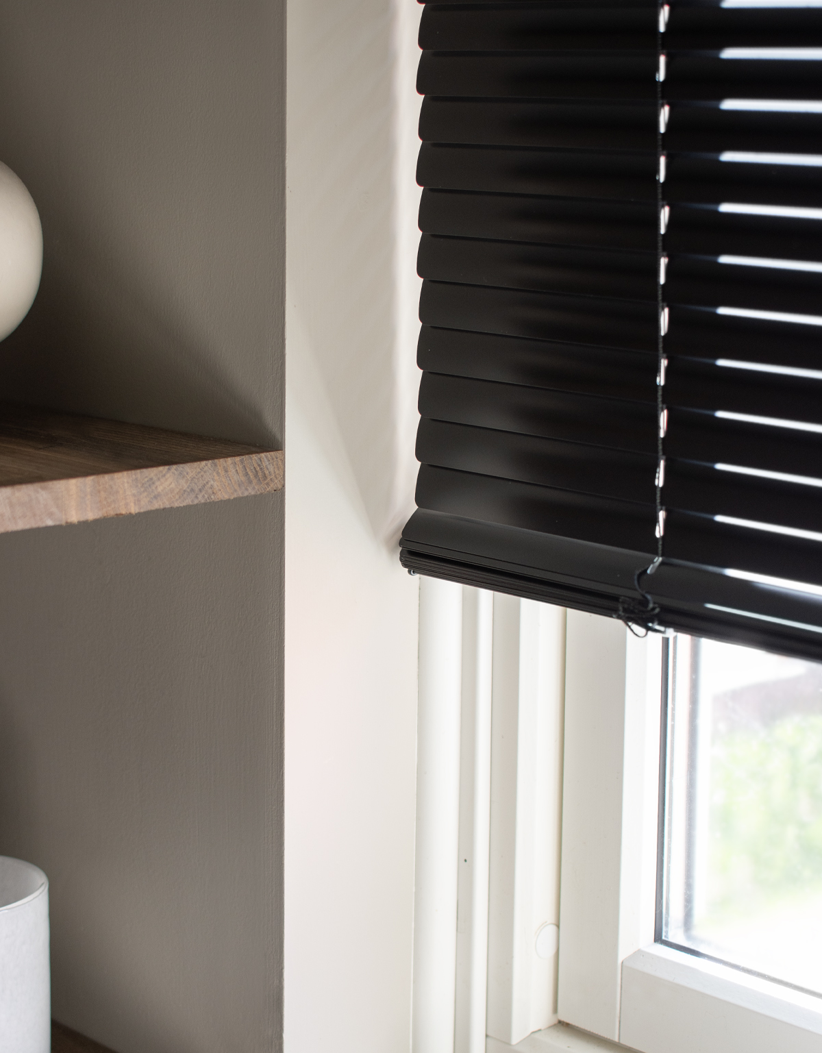 Närbild på lamellerna på en svart persienn